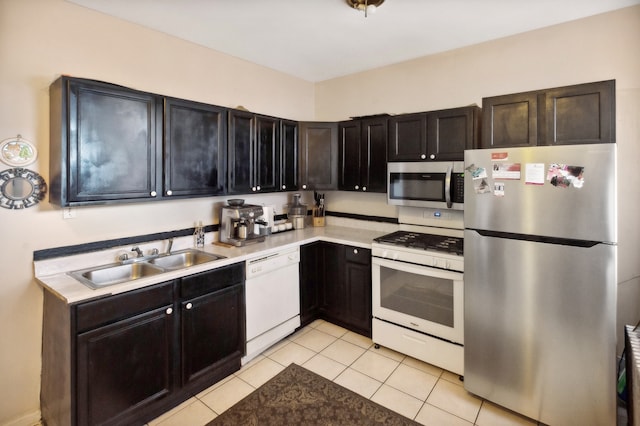 kitchen with stainless steel appliances, sink, and light tile patterned flooring