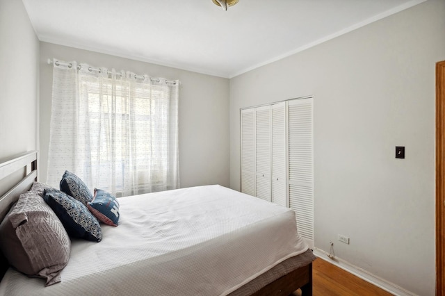 bedroom featuring a closet, baseboards, and wood finished floors