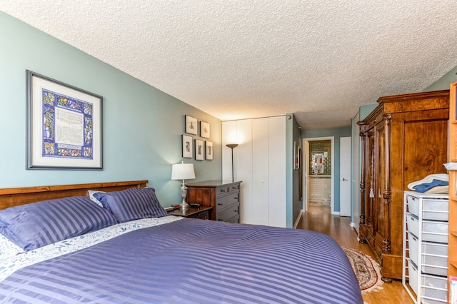 bedroom with a textured ceiling and hardwood / wood-style floors