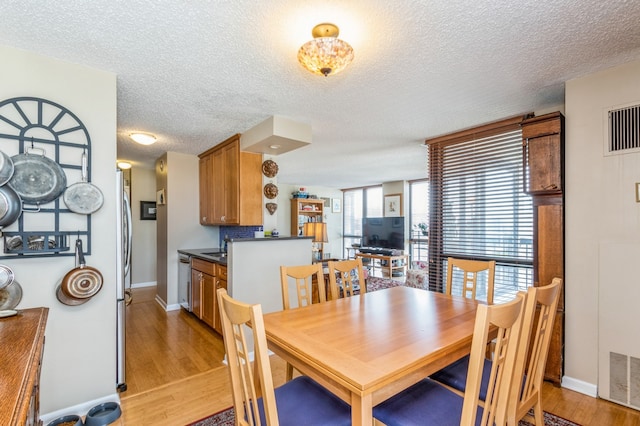 dining area featuring light hardwood / wood-style floors and a textured ceiling