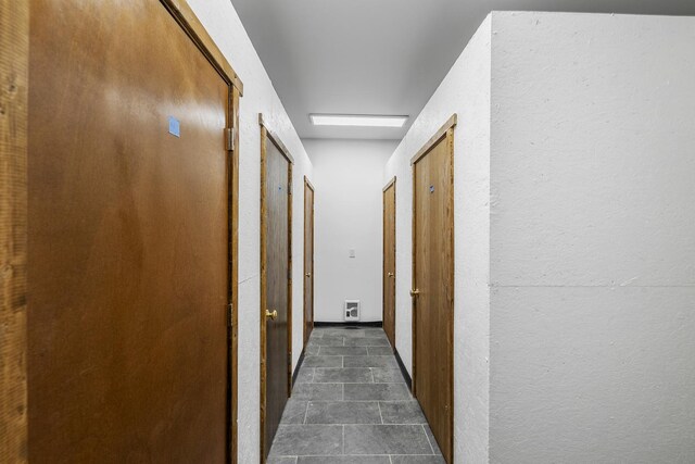 hallway featuring dark tile patterned floors