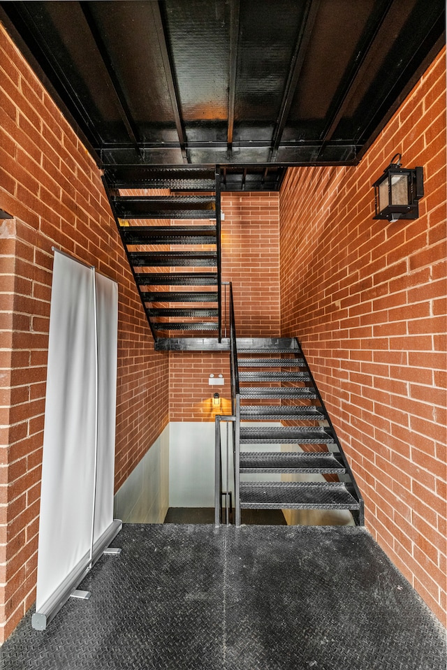 stairs featuring brick wall