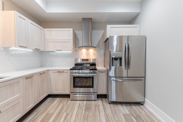 kitchen with appliances with stainless steel finishes, decorative light fixtures, tasteful backsplash, light brown cabinets, and wall chimney exhaust hood