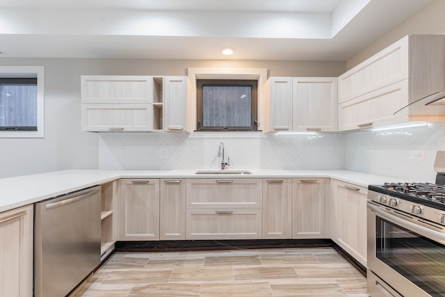 kitchen featuring decorative backsplash, light brown cabinetry, appliances with stainless steel finishes, and sink