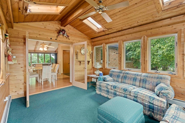 carpeted living room with vaulted ceiling with skylight, baseboard heating, wooden ceiling, and ceiling fan