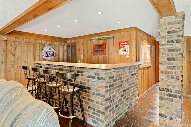 bar with a baseboard heating unit, wood walls, and brick wall