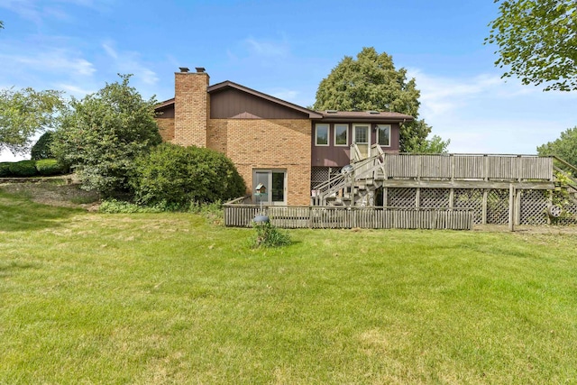 rear view of property featuring a deck and a lawn