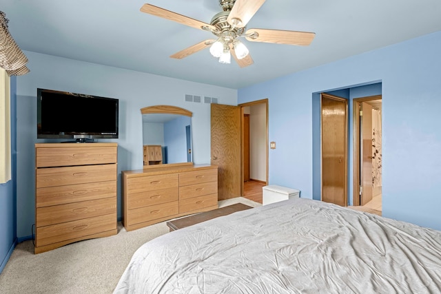 carpeted bedroom featuring ensuite bath and ceiling fan