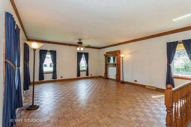 unfurnished living room featuring ceiling fan, ornamental molding, and light parquet floors