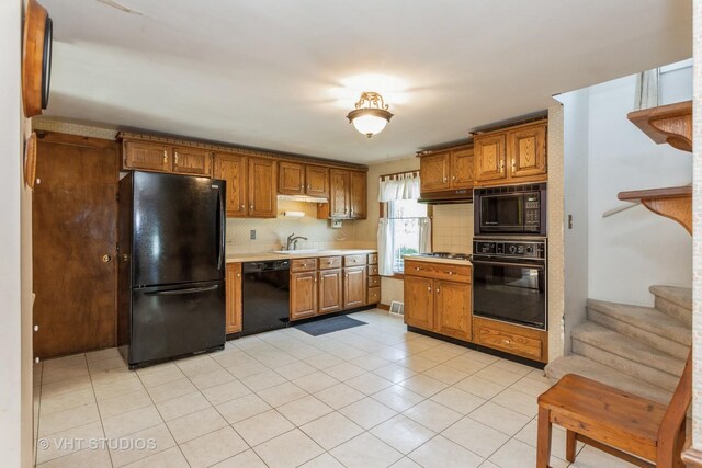 kitchen with black appliances, sink, backsplash, and light tile patterned floors