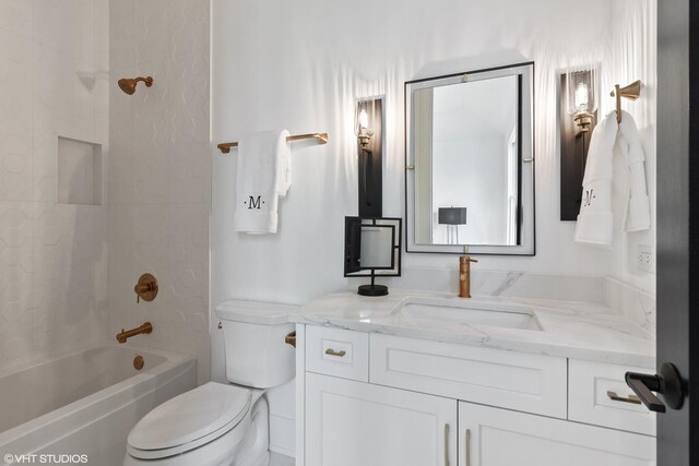 full bathroom with vanity, tiled shower / bath combo, and toilet