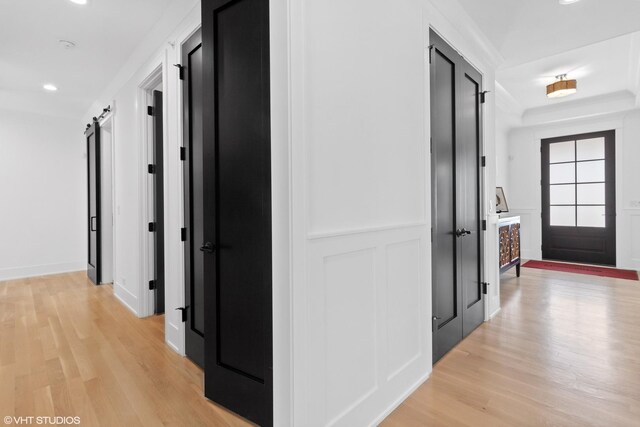 hallway with light hardwood / wood-style floors and a barn door