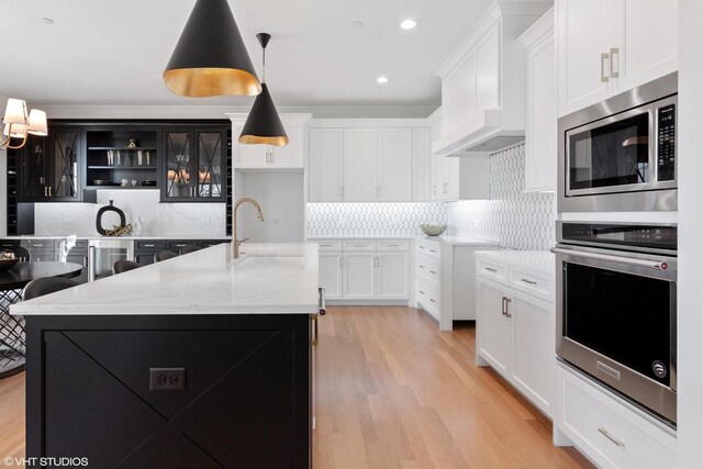 kitchen featuring sink, decorative backsplash, stainless steel appliances, and custom range hood