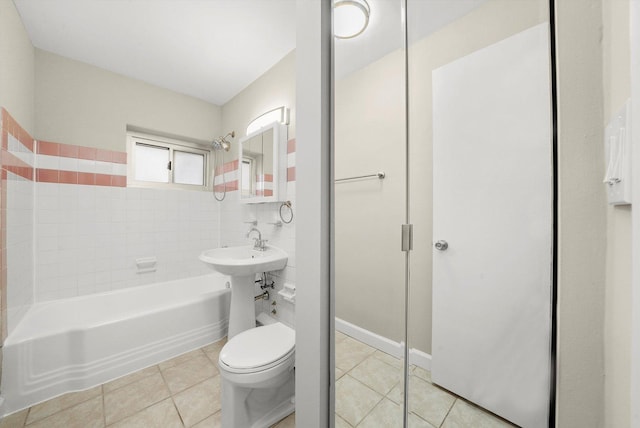 bathroom with tile patterned flooring, a bathtub, and toilet