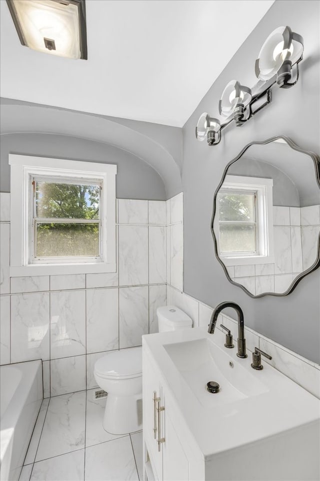 bathroom with tile patterned flooring, tile walls, toilet, and vanity