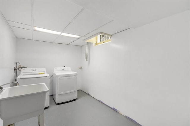 clothes washing area with separate washer and dryer and sink