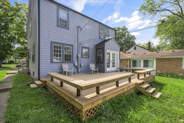 rear view of property featuring french doors, a yard, and a wooden deck