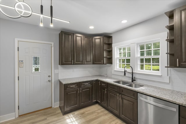 kitchen with tasteful backsplash, light wood-type flooring, dishwasher, pendant lighting, and sink