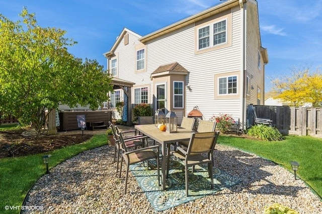 rear view of property with a yard, a hot tub, and a patio area