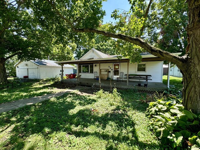 view of front of property with a porch, an outbuilding, and a front yard