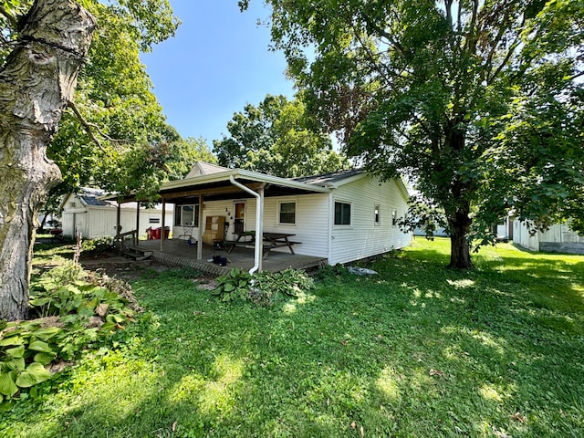 back of house with a patio and a yard