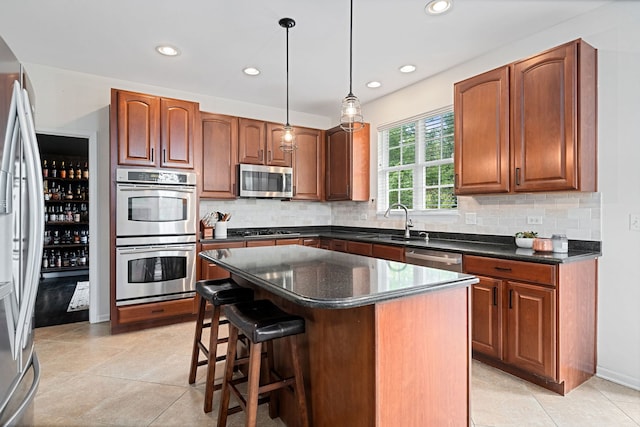 kitchen featuring stainless steel appliances, sink, decorative light fixtures, a center island, and light tile patterned flooring