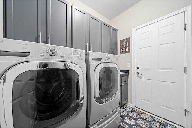 washroom featuring washer and clothes dryer and cabinets