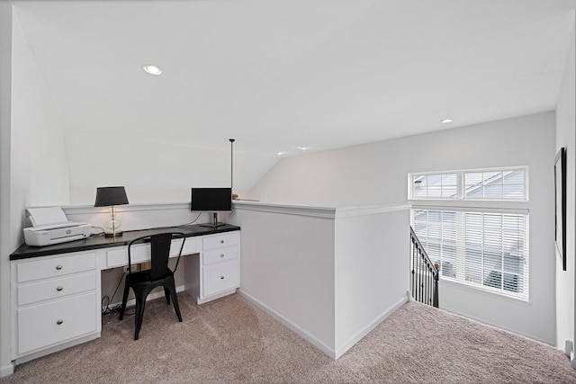 carpeted office space featuring vaulted ceiling