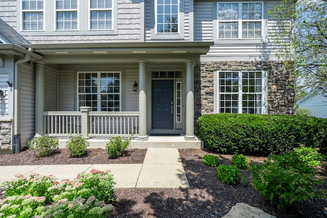 view of exterior entry featuring covered porch