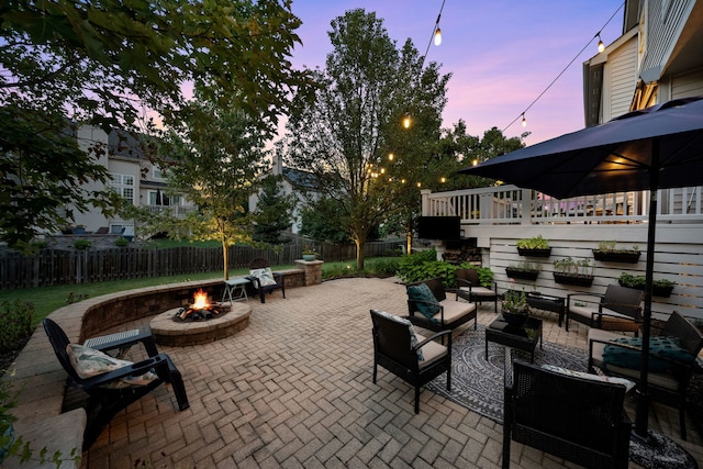 patio terrace at dusk with an outdoor living space with a fire pit