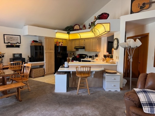 kitchen with range, light carpet, a kitchen bar, kitchen peninsula, and black refrigerator