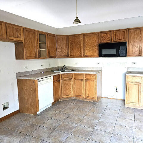 kitchen featuring white dishwasher, hanging light fixtures, and sink