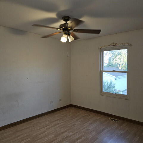 empty room featuring hardwood / wood-style flooring and ceiling fan