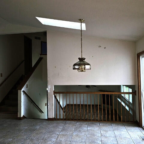 empty room featuring lofted ceiling and a notable chandelier