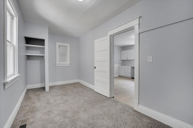 unfurnished bedroom featuring a closet and light colored carpet