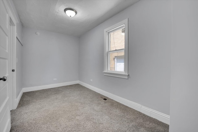 spare room with carpet and a textured ceiling