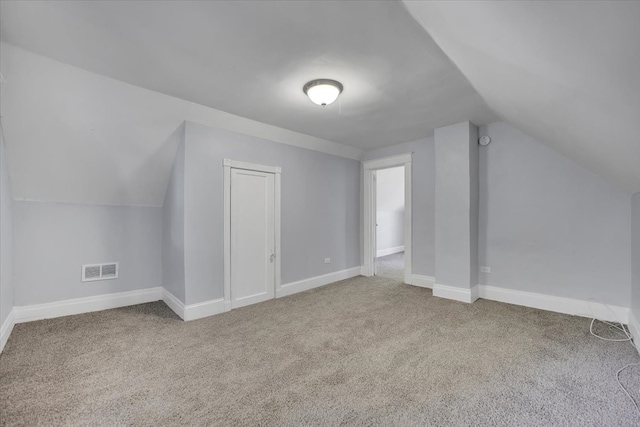 additional living space with carpet and vaulted ceiling