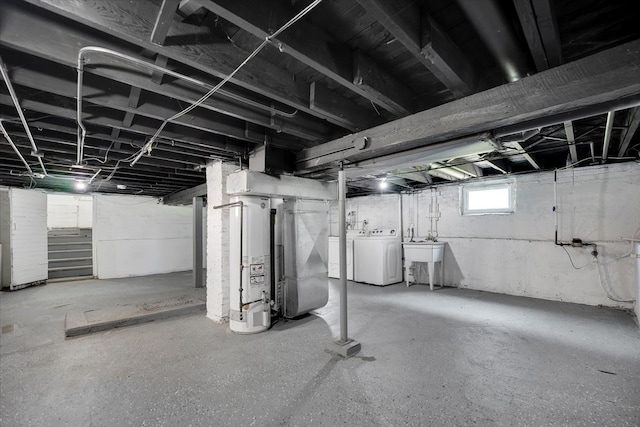 basement featuring sink, independent washer and dryer, and gas water heater