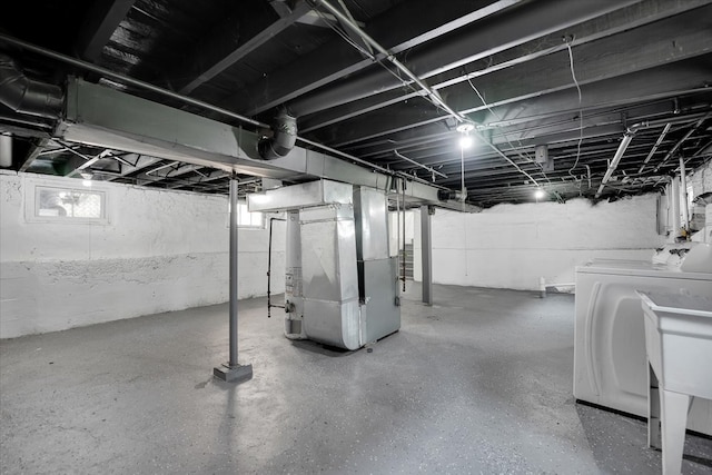 basement with washing machine and dryer and heating unit