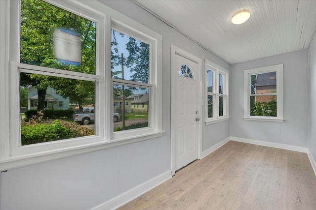 doorway to outside with light hardwood / wood-style flooring and a healthy amount of sunlight