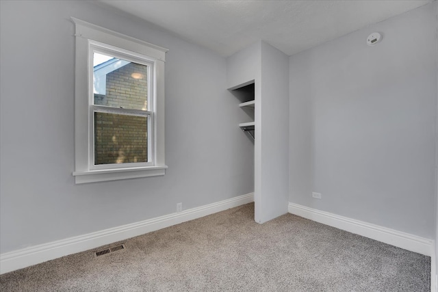 unfurnished bedroom with light carpet and a closet