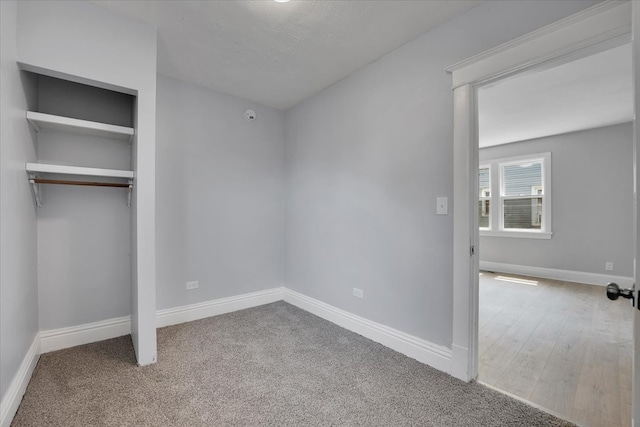 unfurnished bedroom featuring light colored carpet and a closet