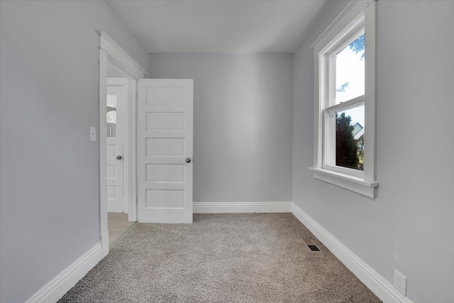 spare room featuring light carpet