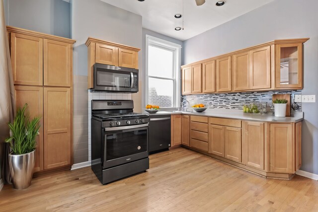 kitchen with backsplash, gas stove, dishwasher, and light hardwood / wood-style floors