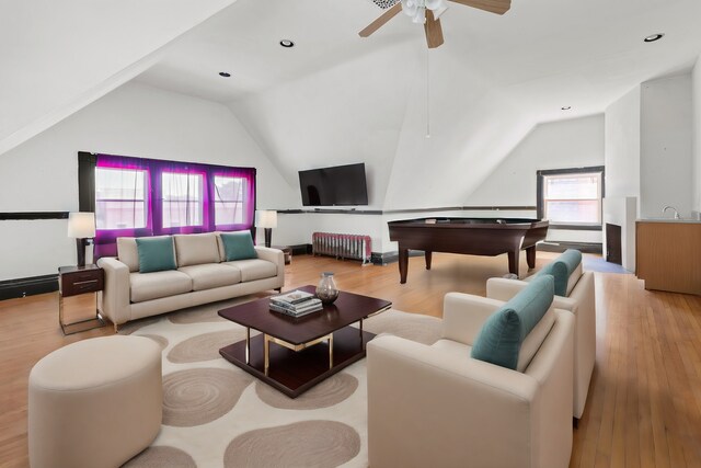 living room with light wood-type flooring, lofted ceiling, and a wealth of natural light