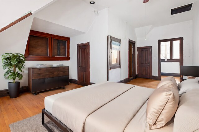 bedroom featuring light hardwood / wood-style flooring and lofted ceiling