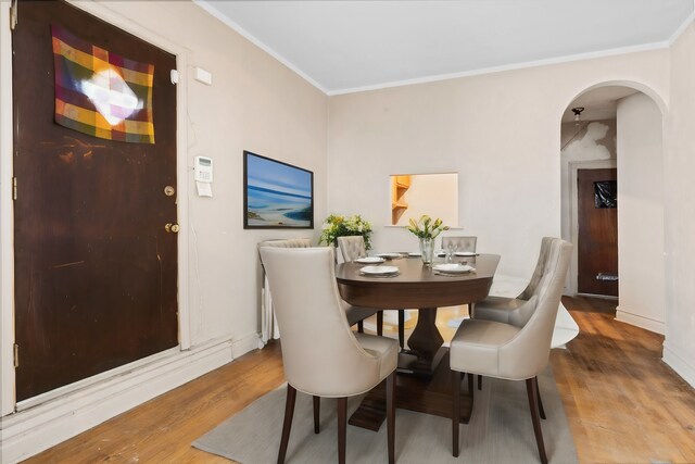 dining area with ornamental molding and hardwood / wood-style floors