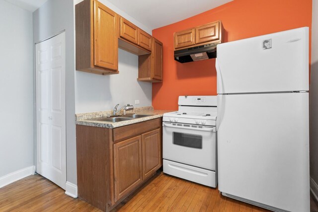 kitchen featuring sink, exhaust hood, white appliances, and light hardwood / wood-style floors