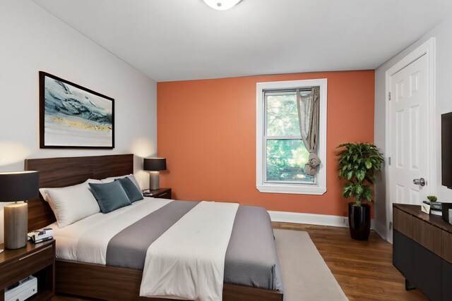 bedroom with dark hardwood / wood-style flooring