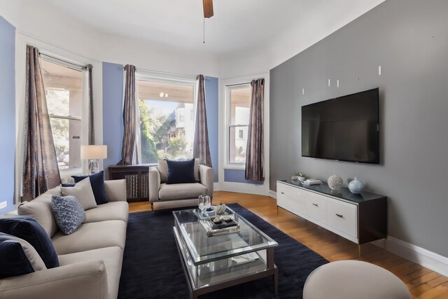 living room featuring ceiling fan and hardwood / wood-style flooring